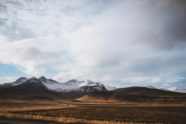 Montagnes enneigées sous un ciel nuageux sauvage