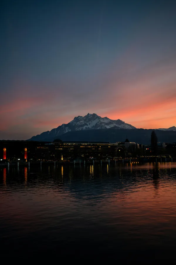 Paysage montagneux au coucher du soleil avec lac et ville illuminée