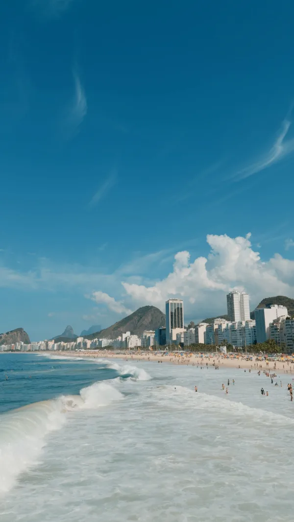 Grande plage urbaine avec vagues et skyline côtière