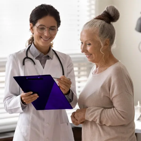 Médecin souriante consultant une patiente âgée en cabinet médical