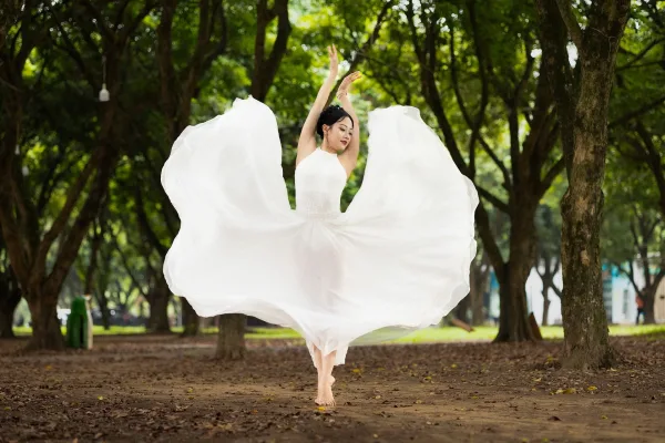 Danseuse en robe blanche exécutant une danse gracieuse en pleine nature
