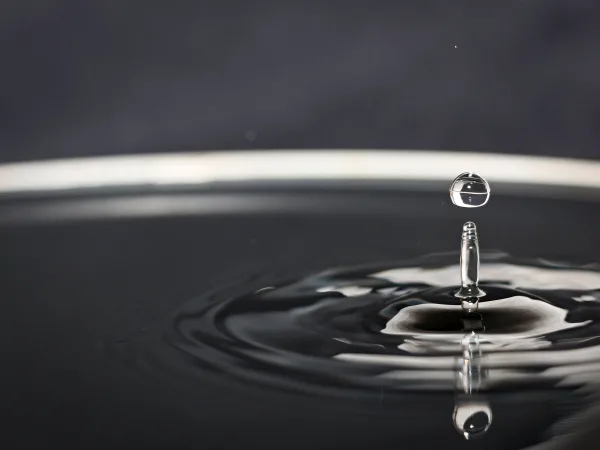 Goutte d’eau en suspension créant des ondulations à la surface