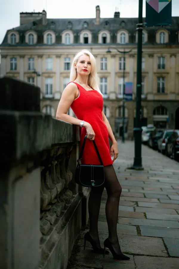 Femme élégante en robe rouge dans une rue urbaine historique