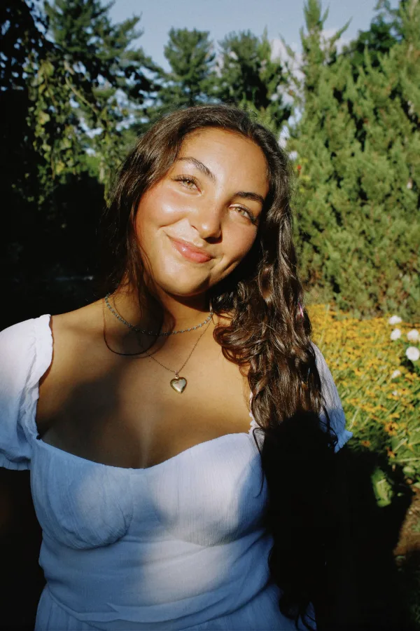 Portrait d’une jeune femme souriante dans un jardin ensoleillé