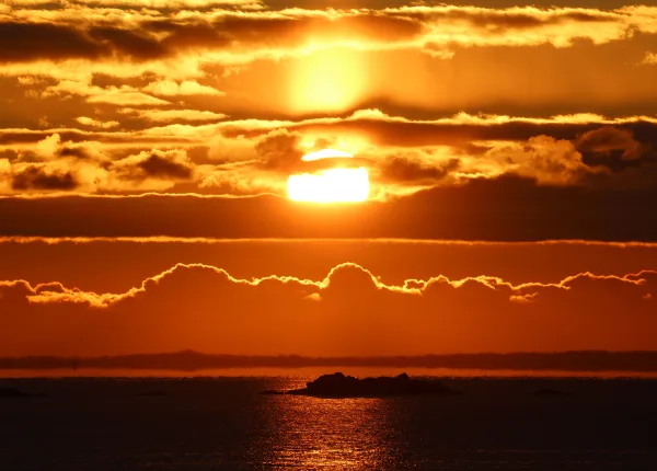 Coucher de soleil spectaculaire sur l’océan avec nuages dorés