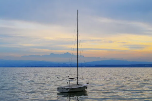 Voilier solitaire sur un lac au coucher du soleil