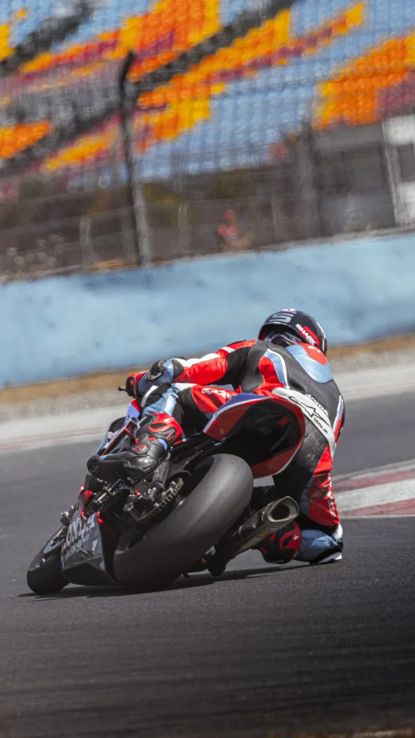 Pilote de moto sportive en pleine prise de virage sur circuit de vitesse