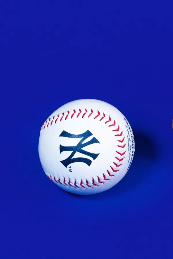 Balle de baseball blanche sur fond bleu avec coutures rouges