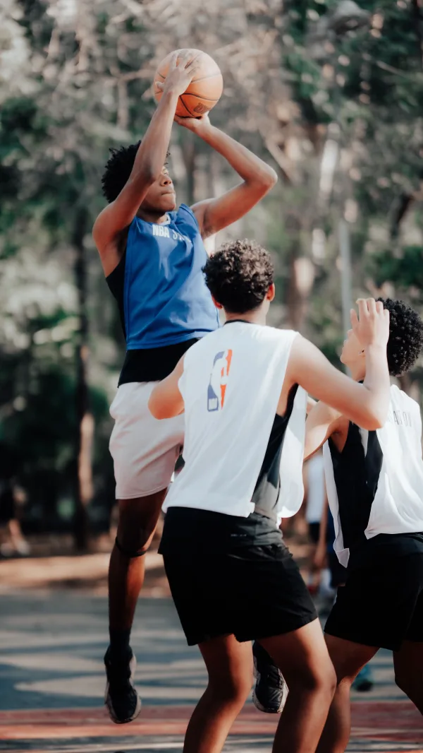 Joueurs de basketball disputant un tir sur un terrain extérieur