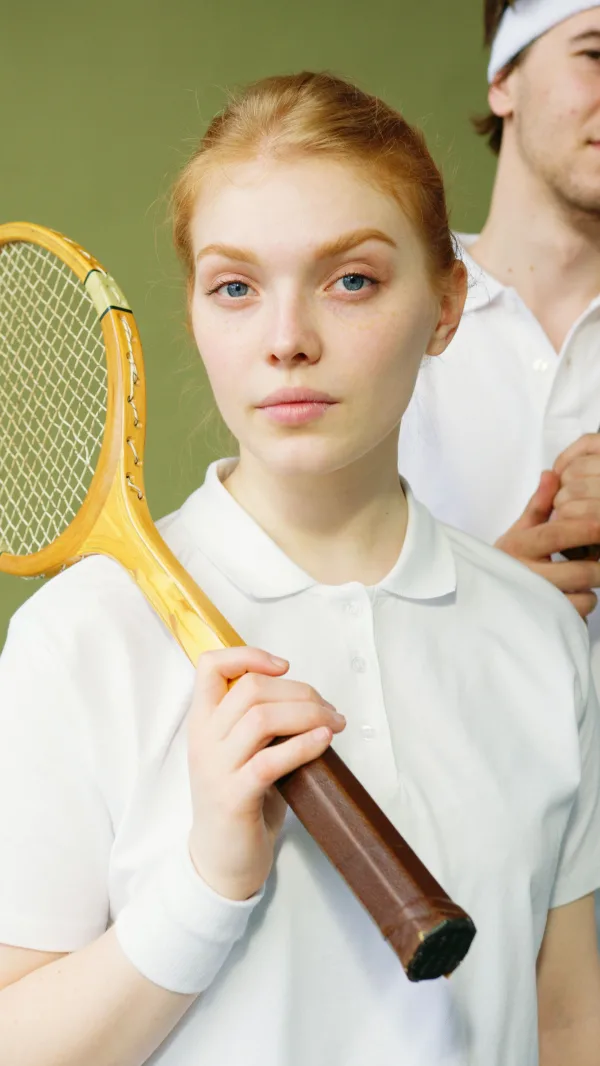 Portrait d’une joueuse de tennis tenant une raquette vintage