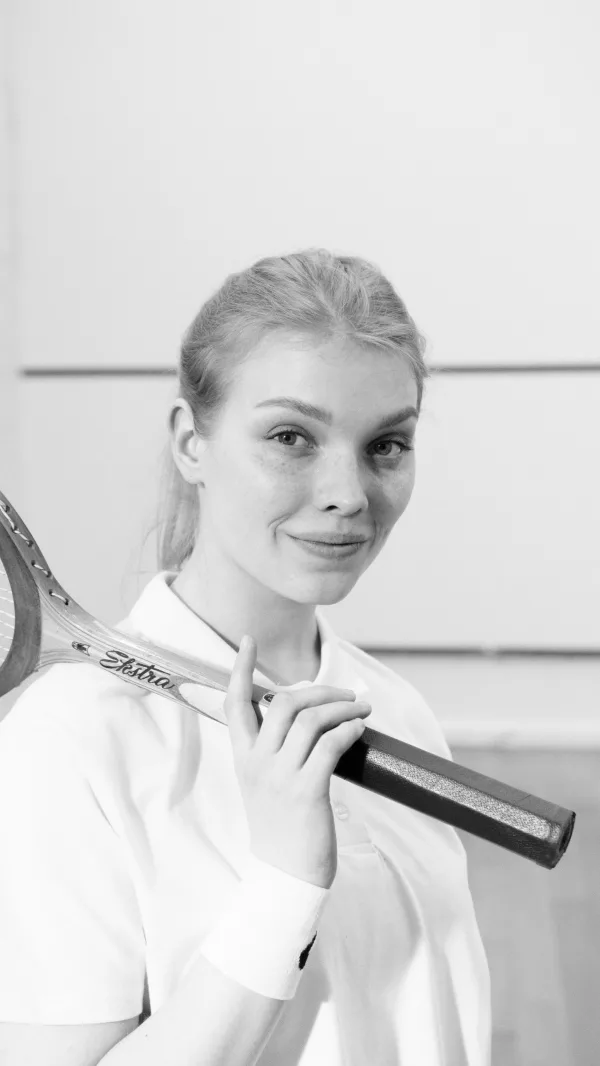 Portrait en noir et blanc d’une joueuse de tennis avec raquette vintage
