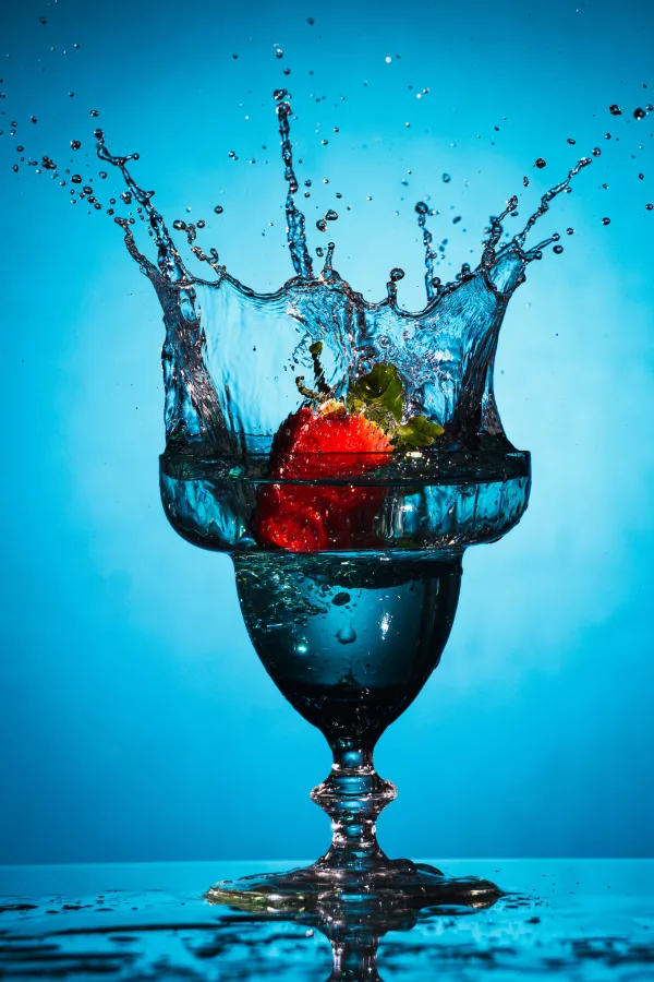Fraise éclaboussant un verre d’eau – photographie splash haute vitesse