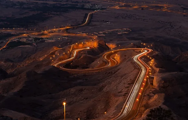 Route sinueuse illuminée dans un paysage désertique de nuit
