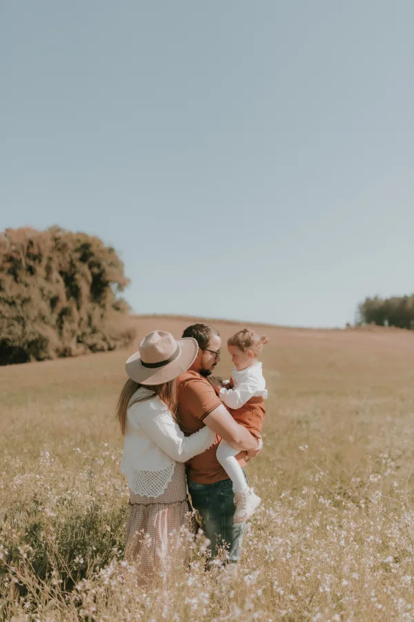 Famille avec enfant profitant d’une promenade dans un champ ensoleillé