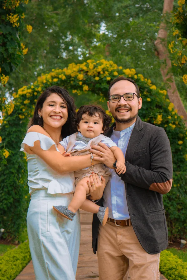 Portrait de famille avec bébé dans un jardin fleuri