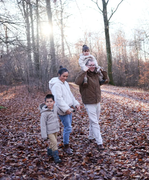 Famille en promenade dans une forêt aux couleurs d’automne