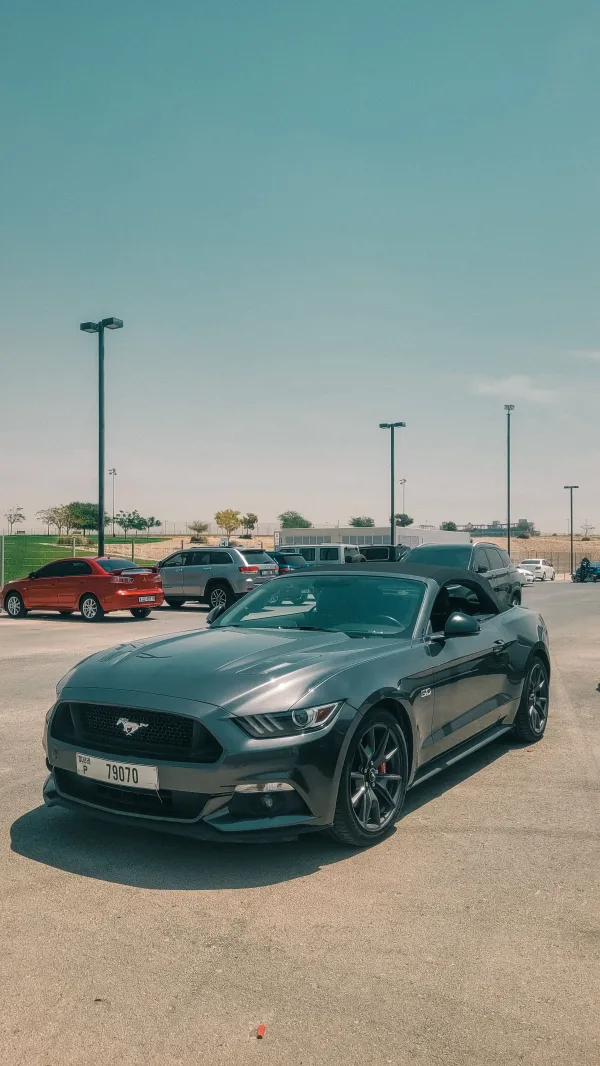 Cabriolet sportif gris stationné sur un parking en plein jour