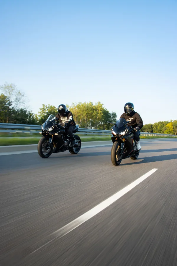 Deux motards en motos sportives roulant sur une route