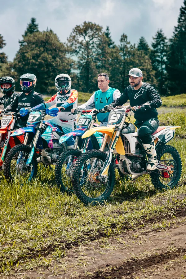 Groupe de pilotes de motocross alignés sur leurs motos tout-terrain