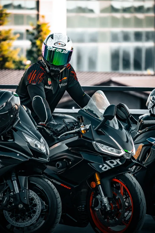 Motard équipé sur une moto sportive noire en milieu urbain