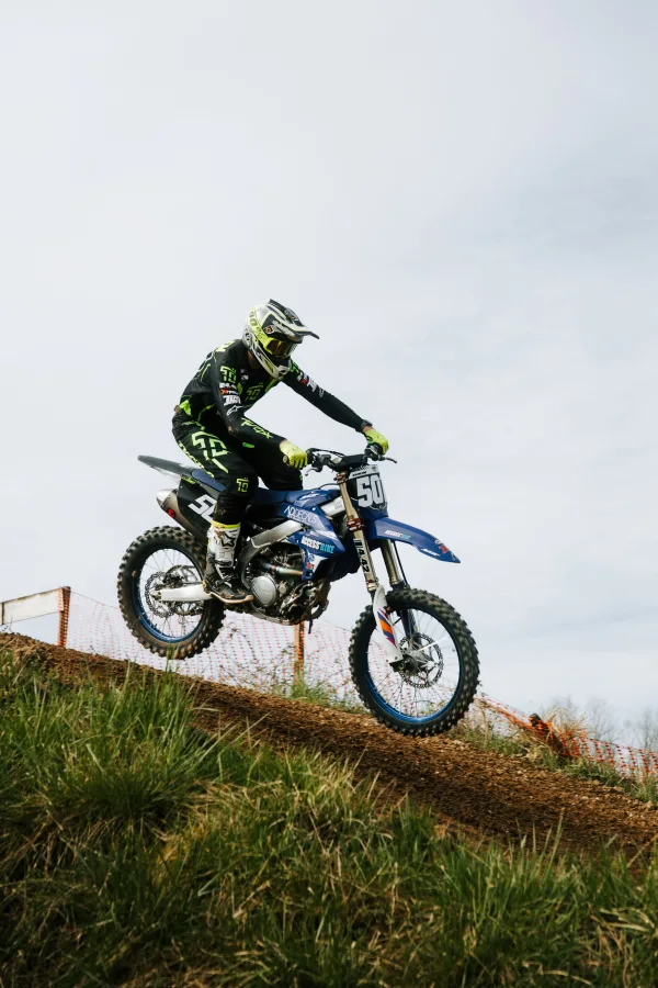 Pilote de motocross sur moto bleue lors d’une descente en piste tout-terrain