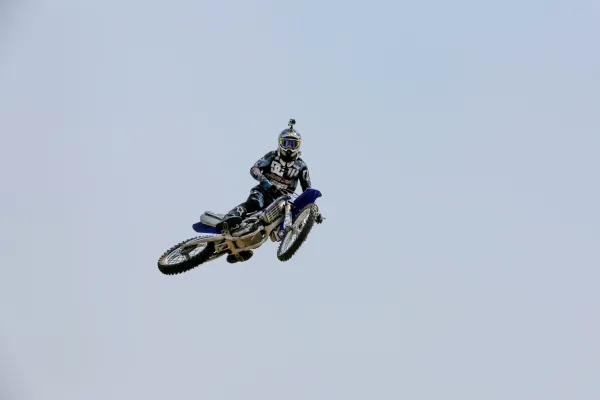 Pilote de motocross réalisant un saut freestyle spectaculaire dans les airs