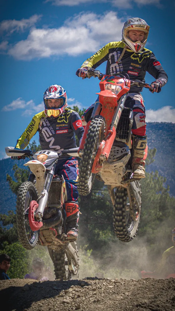 Deux pilotes de motocross en plein saut lors d’une course tout-terrain