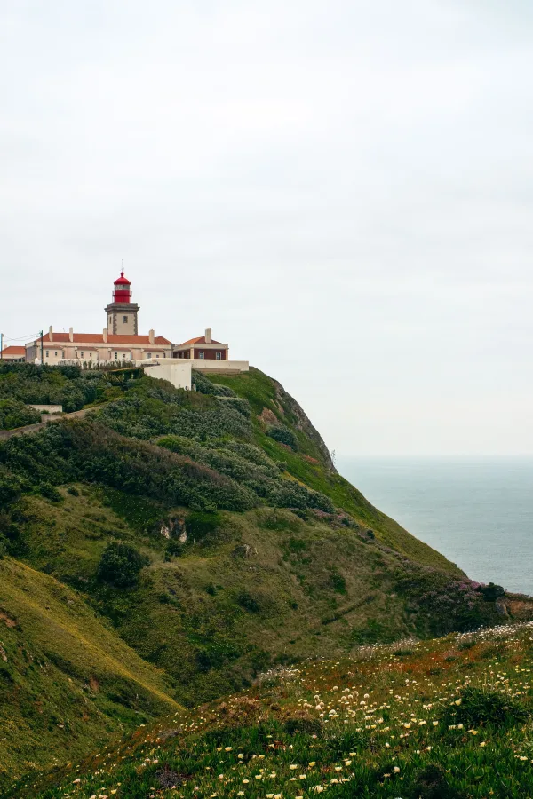 Phare rouge sur une falaise côtière dominant l’océan