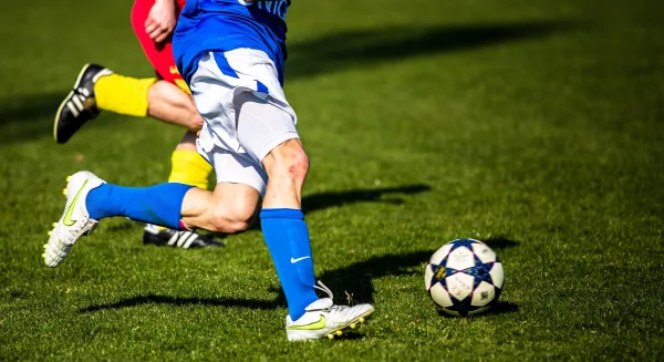 Joueurs de football en pleine action disputant le ballon sur la pelouse