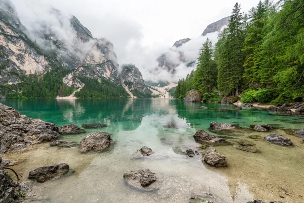 Lac de montagne aux eaux cristallines entouré de falaises et de forêts