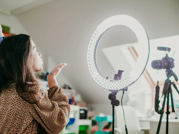 Créatrice de contenu filmant une vidéo avec ring light et caméra professionnelle