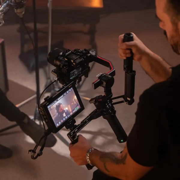 Vidéaste utilisant un stabilisateur caméra pour un tournage vidéo professionnel
