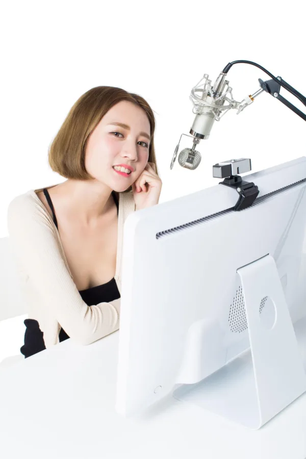 Créatrice de contenu enregistrant un podcast avec microphone et webcam
