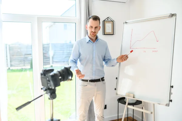 Créateur de contenu enregistrant une formation vidéo devant un tableau blanc