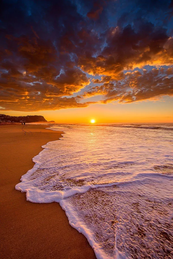 Plage au coucher du soleil avec vagues et ciel spectaculaire