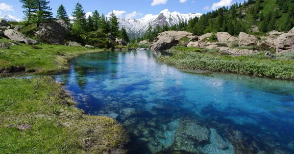 Lac de montagne aux eaux cristallines entouré de sommets enneigés