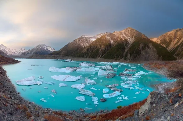 Lac glaciaire turquoise avec icebergs flottants au pied de majestueuses montagnes
