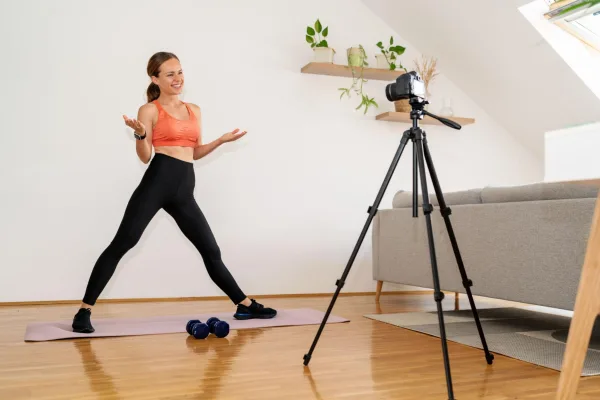 Coach fitness enregistrant un cours de sport en ligne à domicile