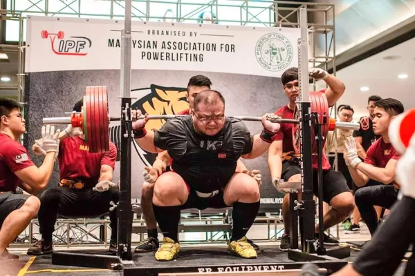Powerlifter réalisant un squat lourd en compétition officielle