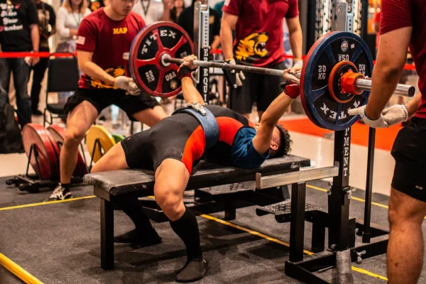 Jeune athlète réalisant un développé couché en compétition de powerlifting