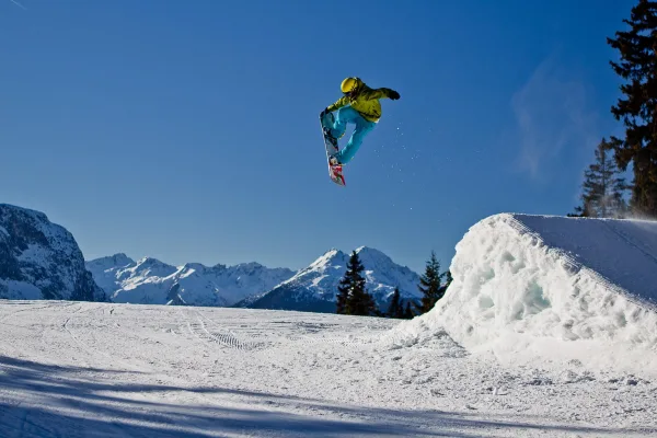Snowboardeur réalisant un saut freestyle spectaculaire en montagne