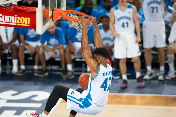 Joueur de basketball réalisant un dunk spectaculaire pendant un match
