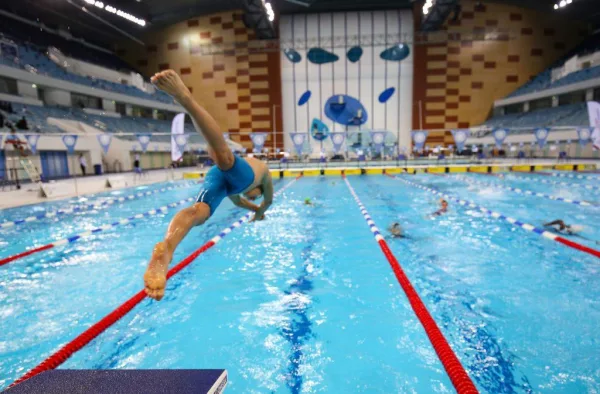 Nageur plongeant dans une piscine olympique pour une séance d'entraînement