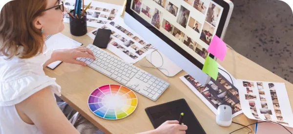 Graphiste retouchant des photos sur ordinateur avec une tablette graphique