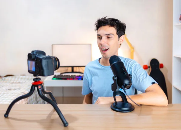 Créateur de contenu enregistrant une vidéo avec caméra et microphone à domicile