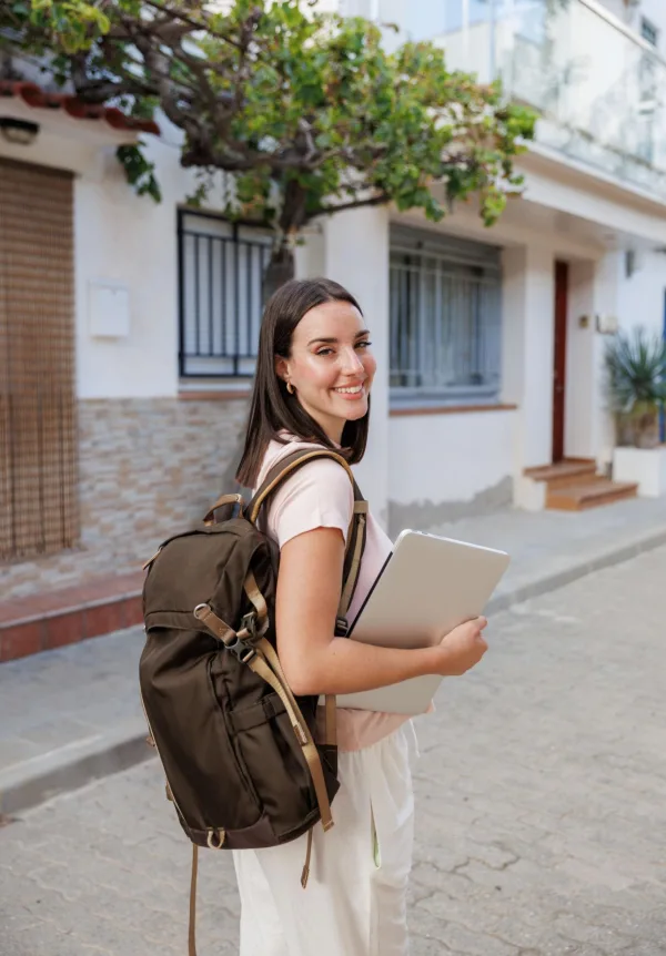 Jeune femme avec sac à dos et ordinateur portable prête à travailler à distance