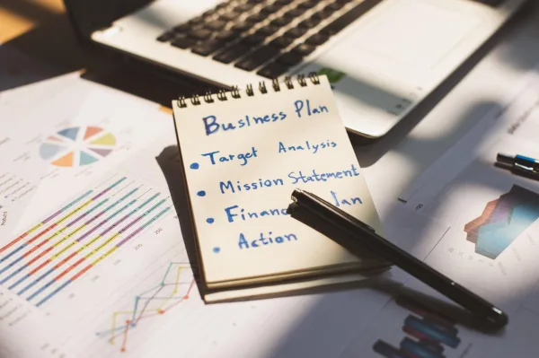 Business plan et stratégie d'entreprise sur un bureau avec ordinateur portable