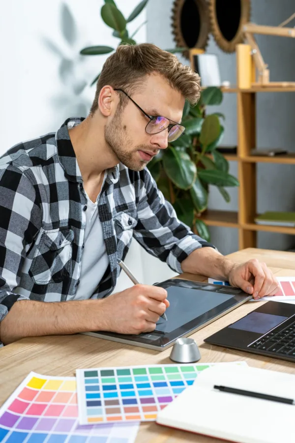 Graphiste professionnel créant une identité visuelle avec une tablette graphique