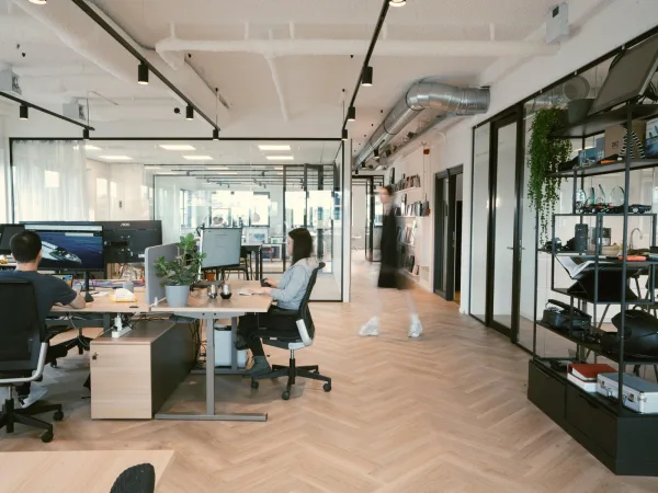 Bureau moderne en open space avec employés travaillant sur ordinateur dans un espace de coworking