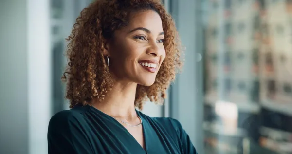 Portrait d'une femme souriante affichant confiance en soi et optimisme